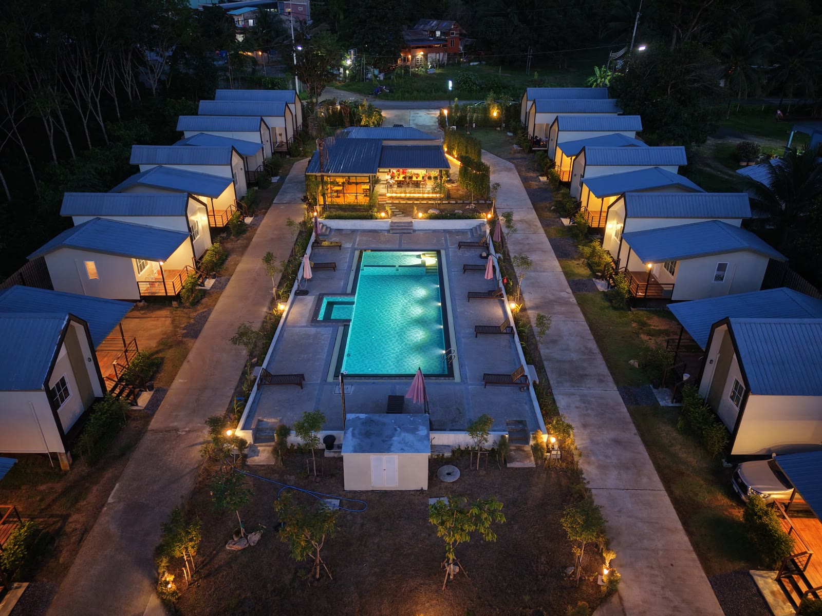 Aerial dusk view of the NaraRin Phuket pool courtyard framed by cabins