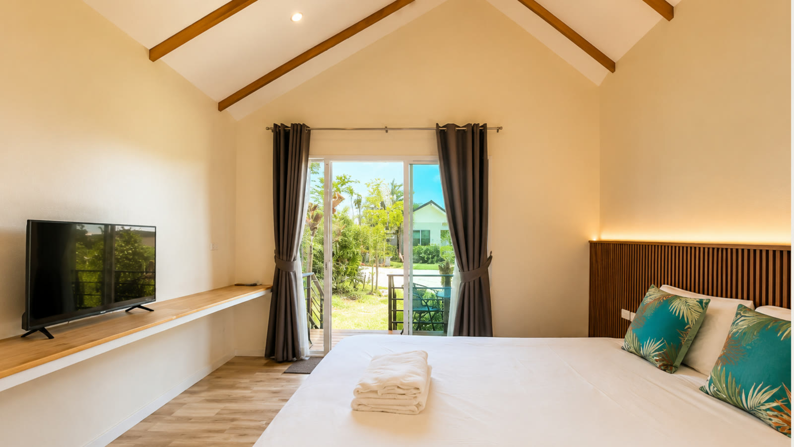 A-frame cabin bedroom at NaraRin Phuket with garden view through terrace doors