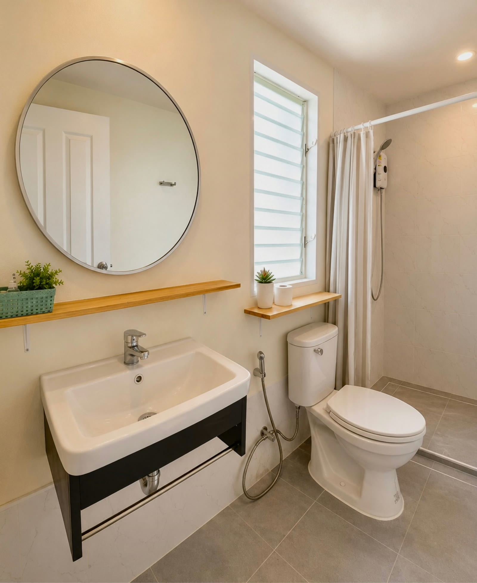 Bathroom in the two-bedroom house at NaraRin Phuket with rain shower and round mirror