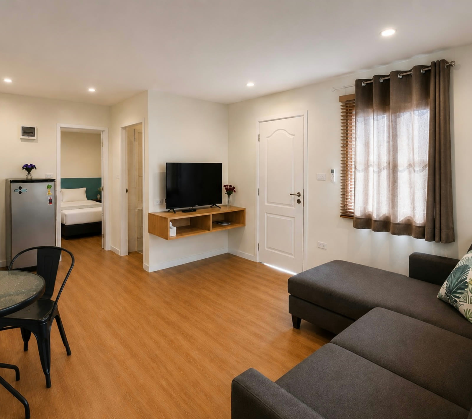 Two-bedroom house living room at NaraRin Phuket — grey sofa, dining nook and kitchen