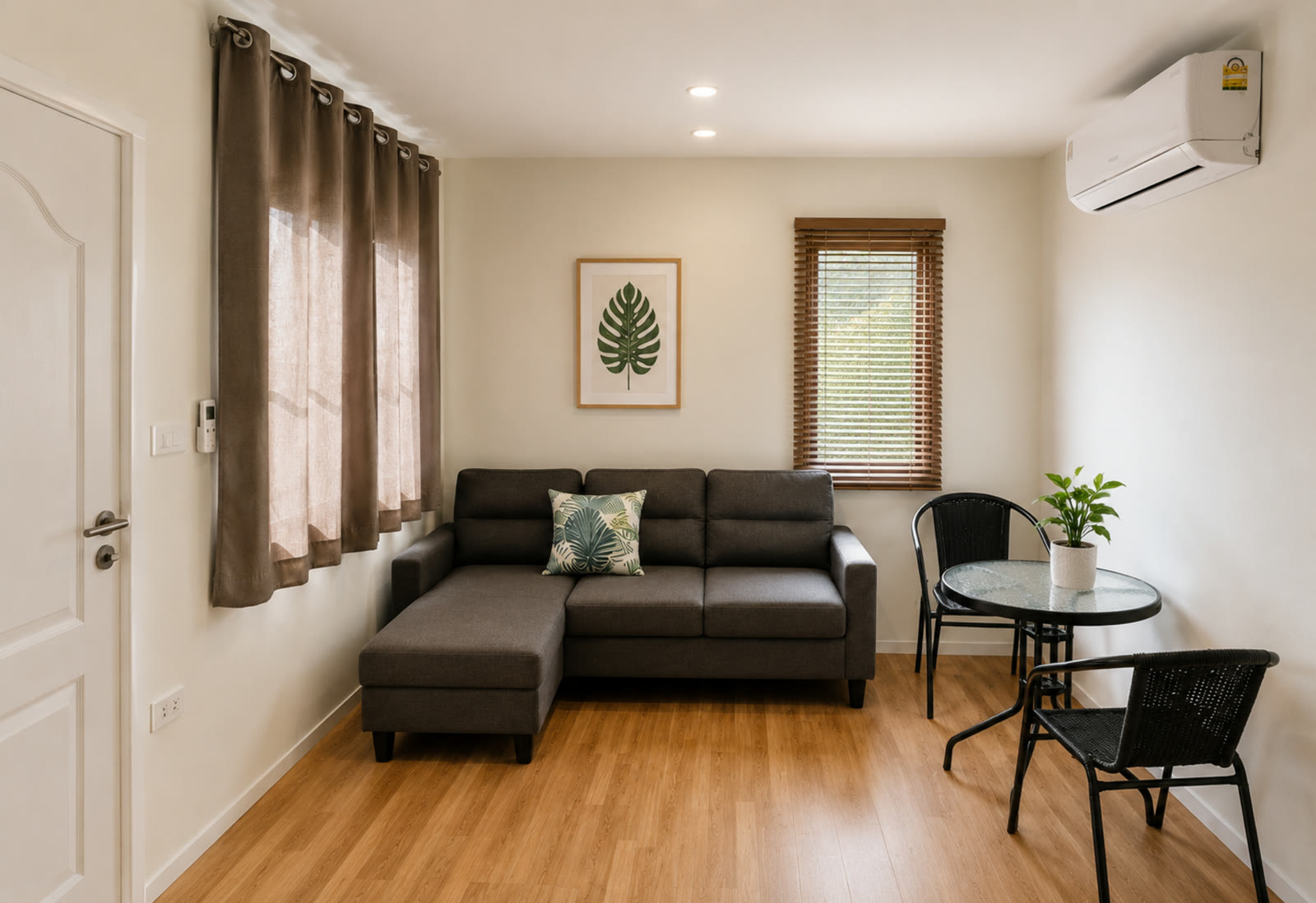 NaraRin Family Suite living room in Phuket resort — sofa, dining table and warm wooden floor