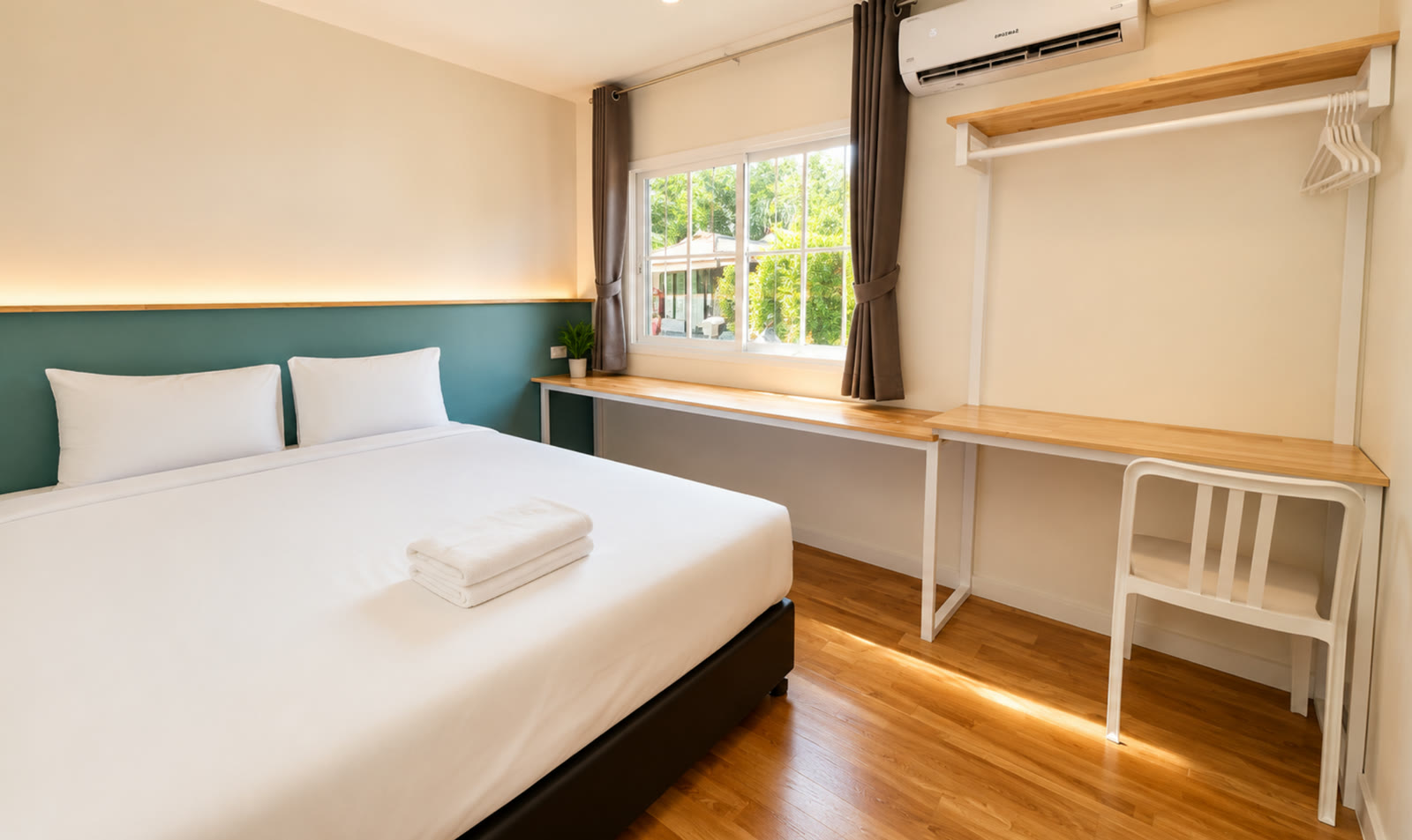 Master bedroom of the two-bedroom house at NaraRin Phuket — king bed with green accent wall